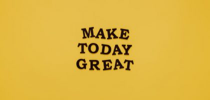 Simple and motivational quote 'Make Today Great' on a minimalist yellow background for inspiration.